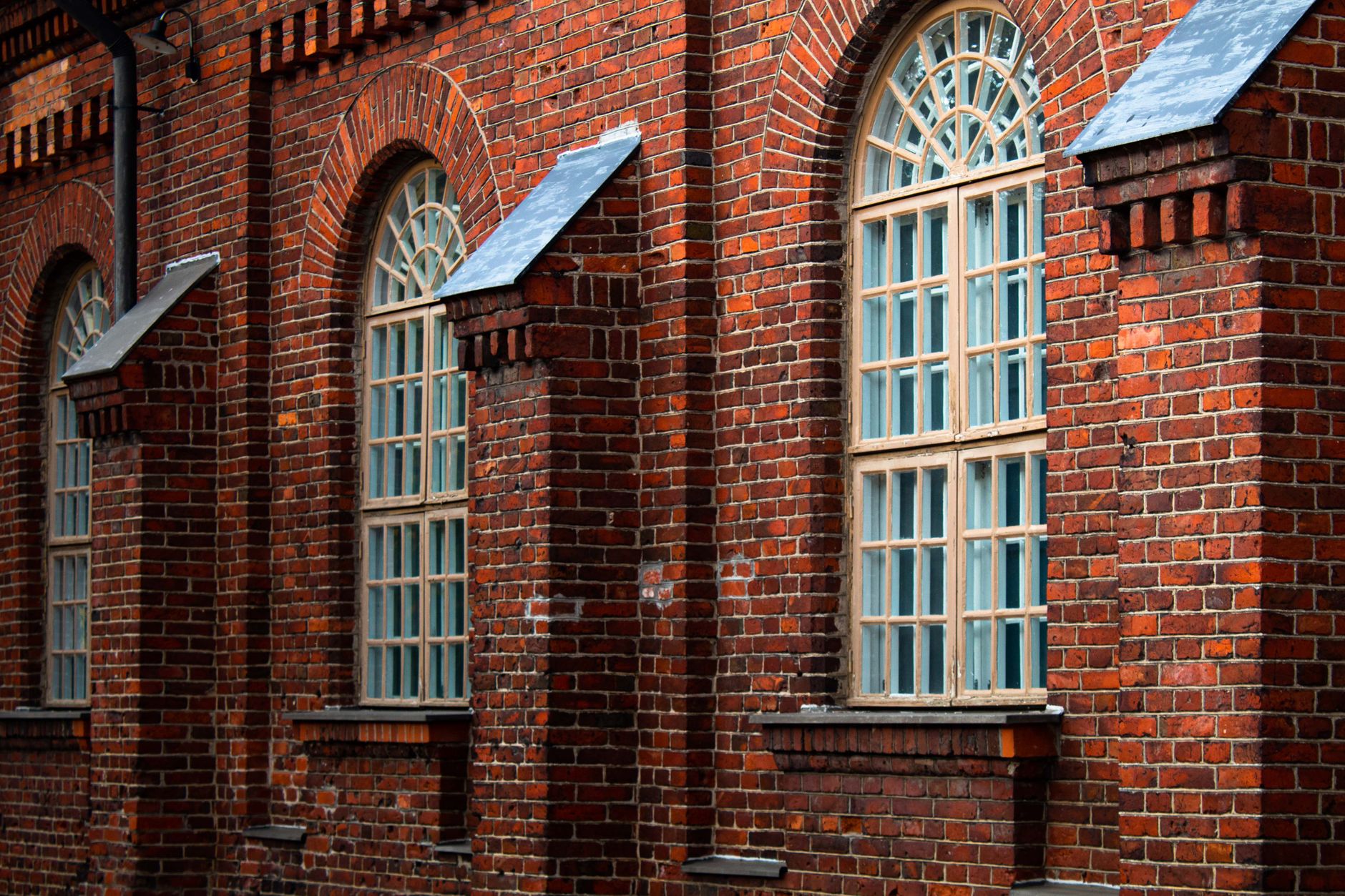 Detailed view of a historic brick building facade with arched windows, showcasing architectural design
